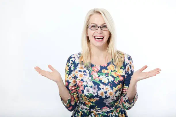 Photo of Surprised beautiful woman with eyeglasses in blue dress on white background. Human face expression, emotions, feeling attitude reaction