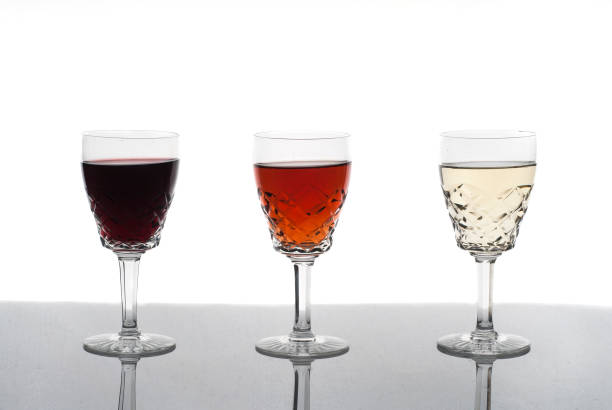 istock Three glasses of wine, rose wine, red wine, white wine, white background 946803338
