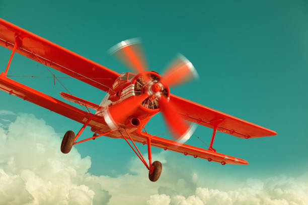 Red biplane flying in the cloudy sky Red biplane flying in the cloudy sky. Retro style airplane commercial airplane propeller airplane aerospace industry stock pictures, royalty-free photos & images