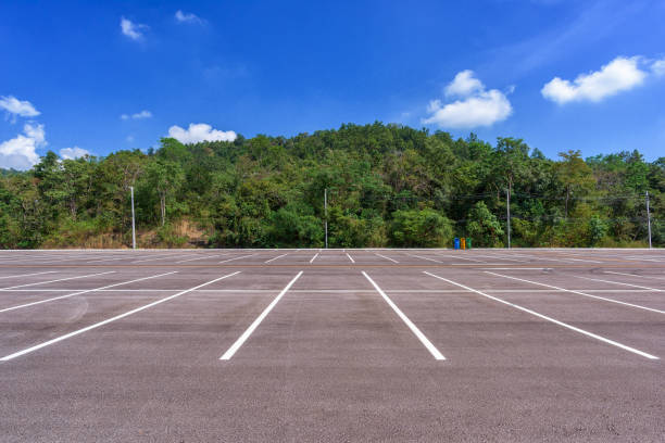 istock Empty parking lot with forest and beautiful blue sky. 946804352
