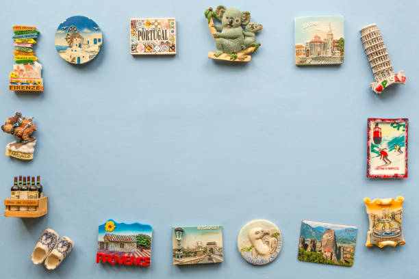 aimants de souvenirs divers de plusieurs pays du monde disposées sur le fond bleu - souvenir de vacances photos et images de collection
