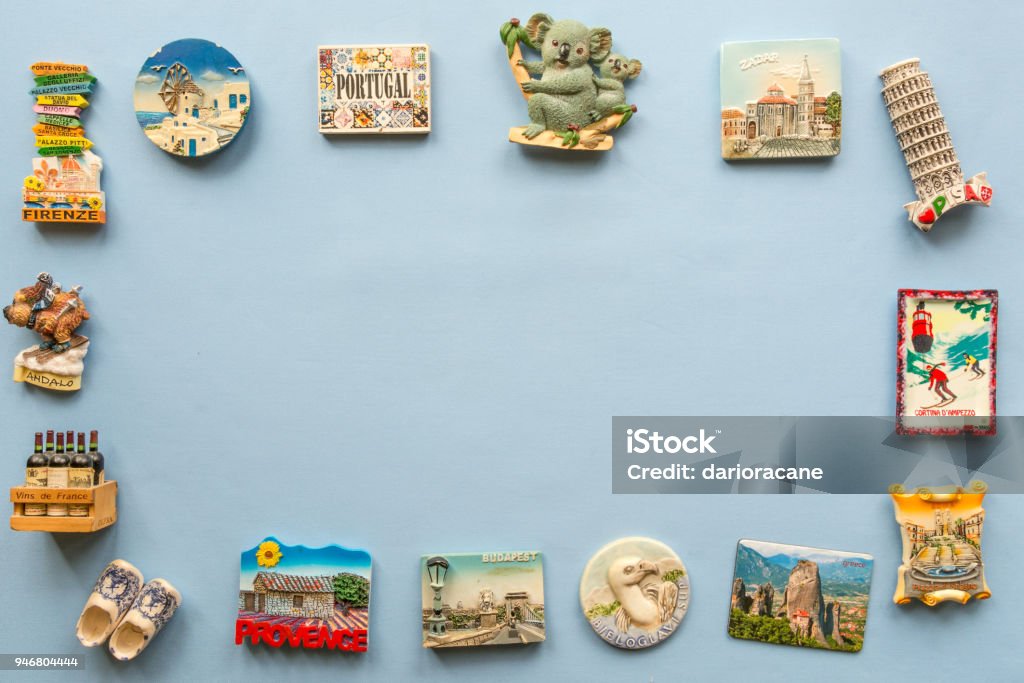 vari magneti souvenir da diversi paesi del mondo disposti sullo sfondo blu - Foto stock royalty-free di Magnete