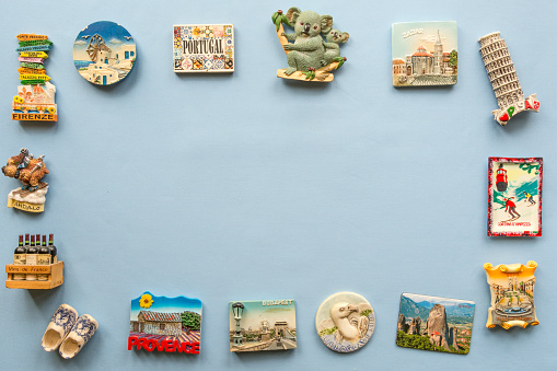 various souvenir magnets from several world country arranged on the blue background