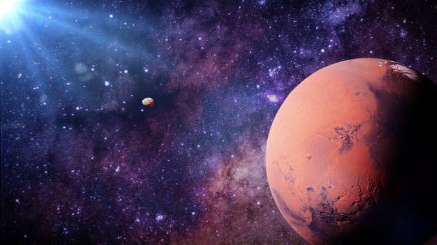 istock planet Mars with it moons Phobos and Deimos lit by the Sun 946810532