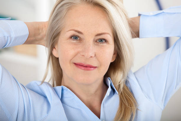 Modern businesswoman. Beautiful middle aged woman looking at camera with smile while siting in the office. Modern businesswoman. Beautiful middle aged woman looking at camera with smile while siting in the office. Female face close-up Ollie stock pictures, royalty-free photos & images