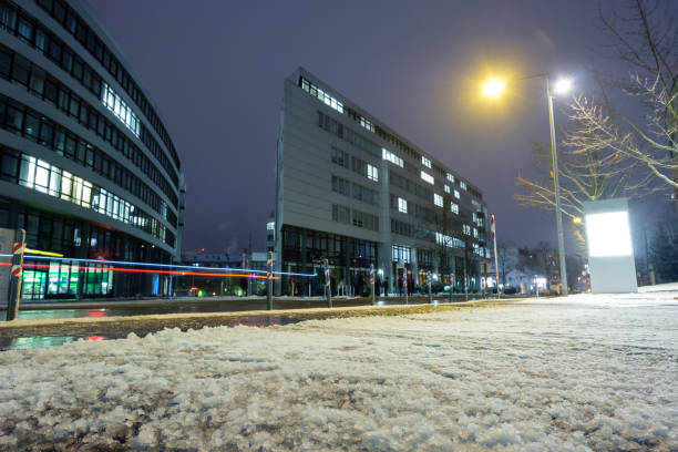 Snow in winter on a sidewalk und blurred car lights at a road
