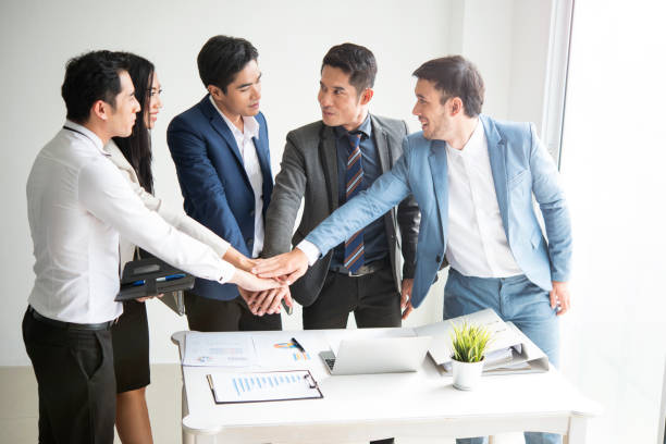 istock young businesspeople putting their hands together. concept teamwork and unity. 946812272
