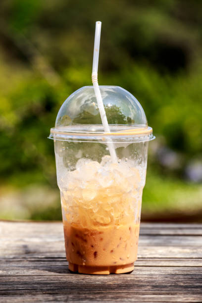 istock Iced milk tea in a plastic cup on wooden table 946820682