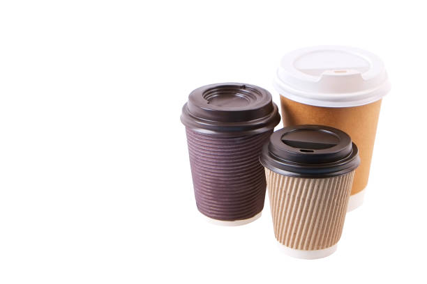 istock Three brown carton double walled paper cups, different sizes, take out, coffee to go. Disposable eco-friendly cardboard mugs for hot beverages w/ cap, isolated white, background, close up, copy space. 946823734