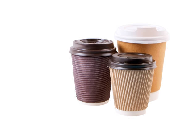 istock Three brown carton double walled paper cups, different sizes, take out, coffee to go. Disposable eco-friendly cardboard mugs for hot beverages w/ cap, isolated white, background, close up, copy space. 946823746