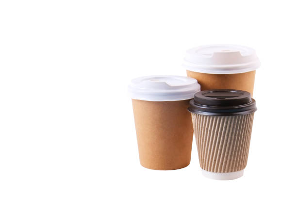 istock Three brown carton double walled paper cups, different sizes, take out, coffee to go. Disposable eco-friendly cardboard mugs for hot beverages w/ cap, isolated white, background, close up, copy space. 946823750