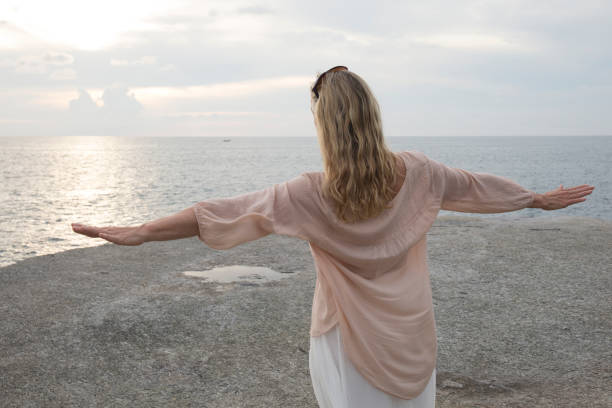 istock Woman walks along coastline, sea behind 946824502