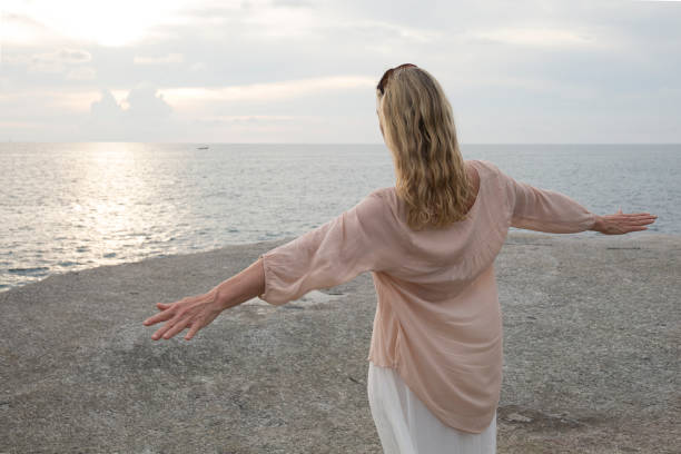 istock Woman walks along coastline, sea behind 946824536