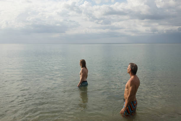 padre e figlio stanno in mare poco profondo, guardando fuori - 11900 foto e immagini stock