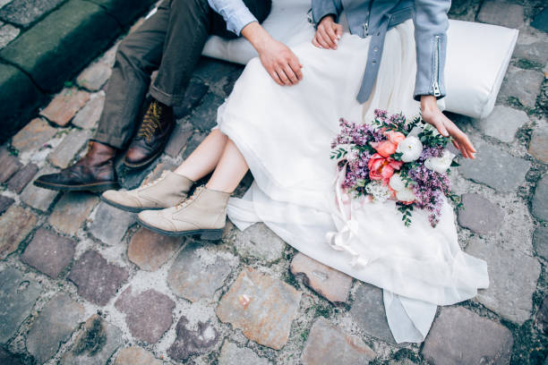 istock Newlyweds sitting on cobble stones 946825160