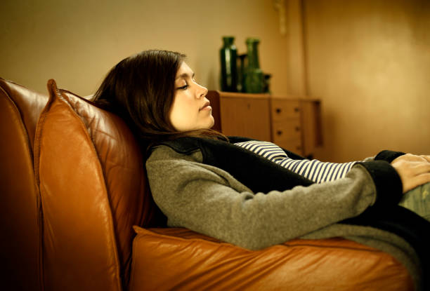 istock Tired woman laying on a sofa 946825488