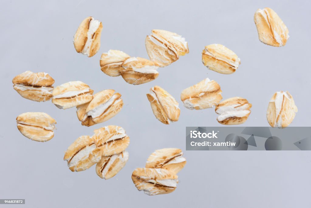 Oat flakes isolated on white background. Close up. Oat flakes isolated on white background with clipping path. Close up. Oats - Food Stock Photo