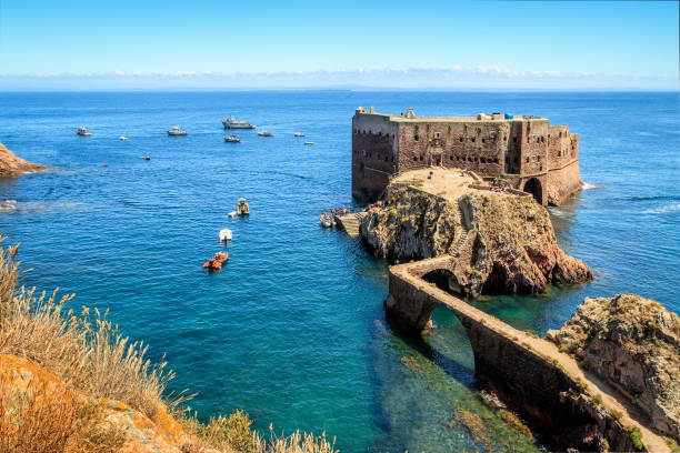 Fort São João Baptista of Berlengas, with anchored boats, seen from Berlenga island, with Peniche coast at sight. stock photo