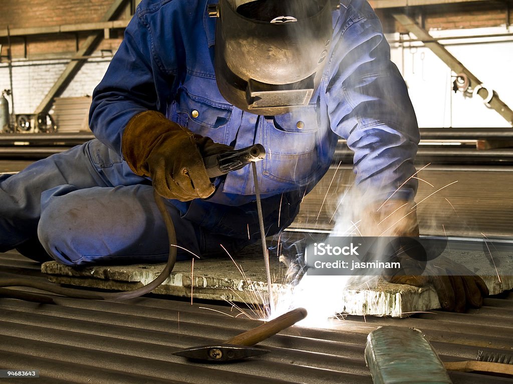 A man at work welding a project  Welder in action. Blue-collar Worker Stock Photo