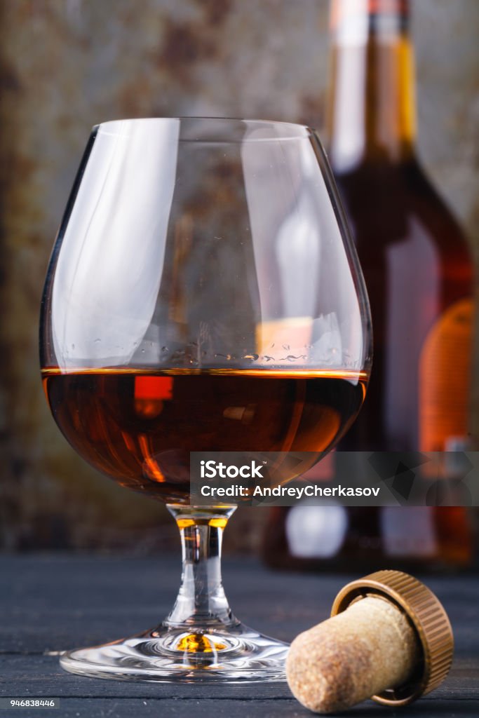 Glass of cognac on rustic ferruginous background Addiction Stock Photo