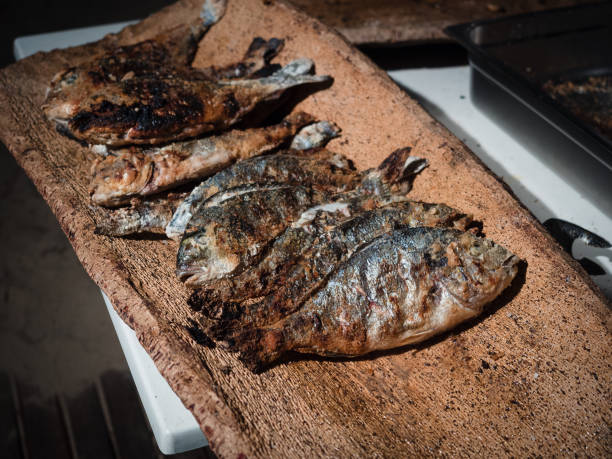 istock Bream cooked on the grill and served on a typical cork tray. 946839928