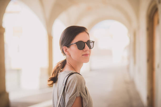 istock Woman smiling while exploring a city and wearing sunglasses 946847416