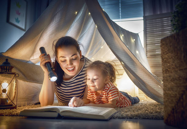 istock Mom and child reading a book 946853634