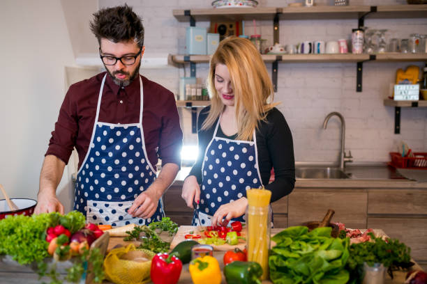 istock Smiling young couple cooking food in the kitchen 946857152