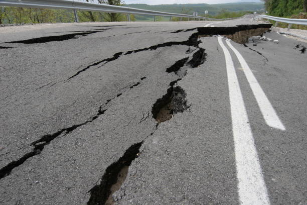 istock Road collapses with huge cracks. International road collapsed down after bad construction. Damaged Highway Road. Asphalt road collapsed and fallen. Erosion 946857448