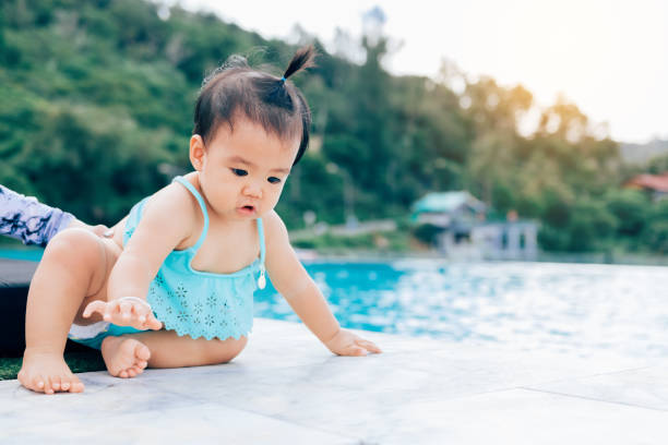istock Baby infant tries to crawl down to the pool alone with danger. 946861736