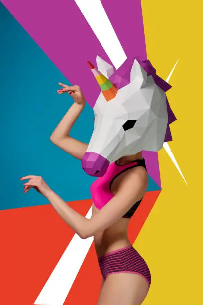 Photo of Slim model wearing colorful unicorn's head.