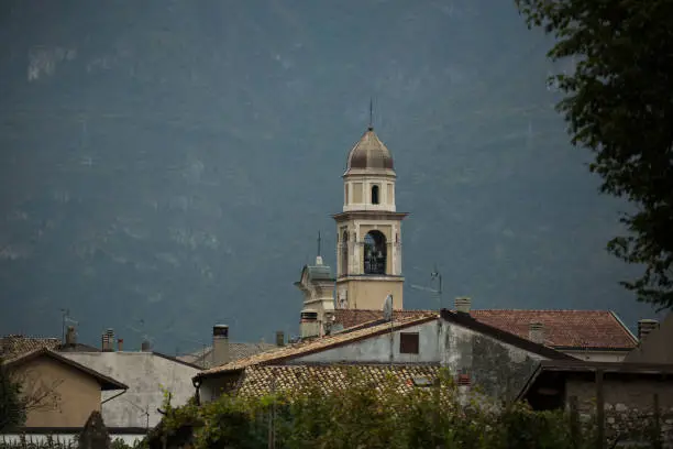 Old church in small Italian town and mountain in front of forest
