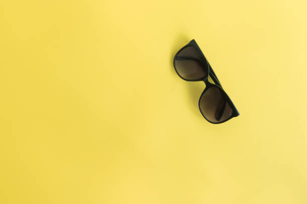 Sunglasses on a yellow background. Top view, flat lay