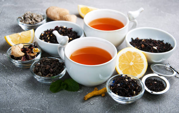 istock Cups of tea with aromatic dry tea in bowls 946879996
