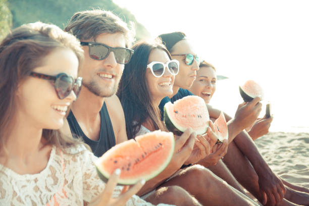 istock Friends eating watermelon on beach 946880988