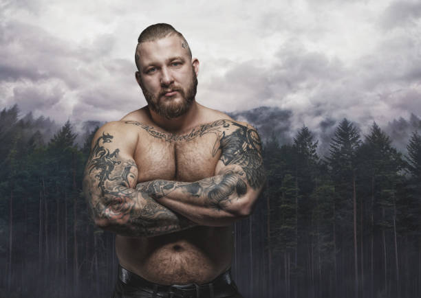 serious tattooed male over dark forest - shirtless men bizarre male imagens e fotografias de stock