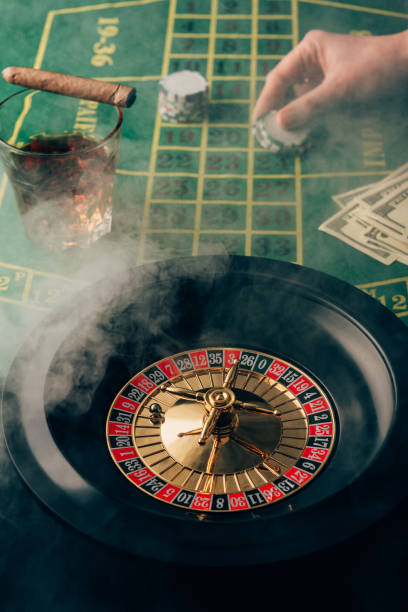 istock Smoke over female hand placing a bet on table with roulette 946885186
