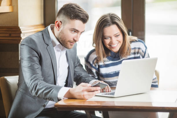 istock Business couple in cafe using laptop 946891754