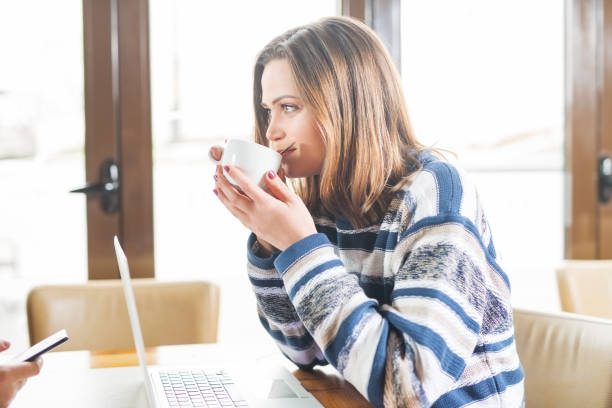 istock Businesswoman drinking coffee and using laptop 946894168