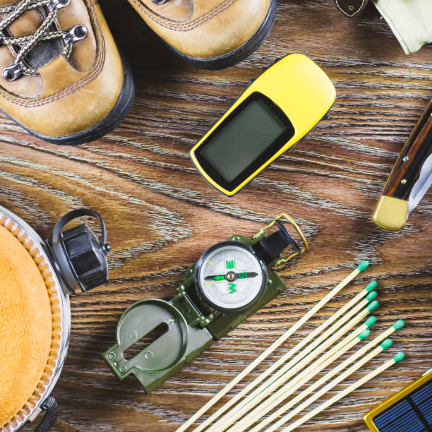 istock Hiking or travel equipment with boots, compass, binoculars, matches on wooden background. Active lifestyle concept. 946894890