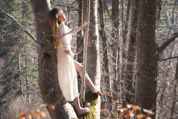 Girl with a flower crown in the forest at early spring day.