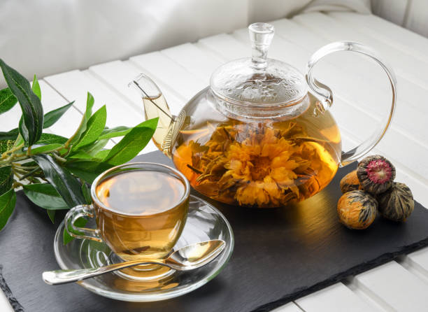 istock Exotic green tea with flowers in glass teapot. 946897670