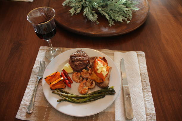 mar y montaña con camote al horno, espárragos, pimientos asados y vino tinto - surf and turf prepared shrimp steak grilled fotografías e imágenes de stock