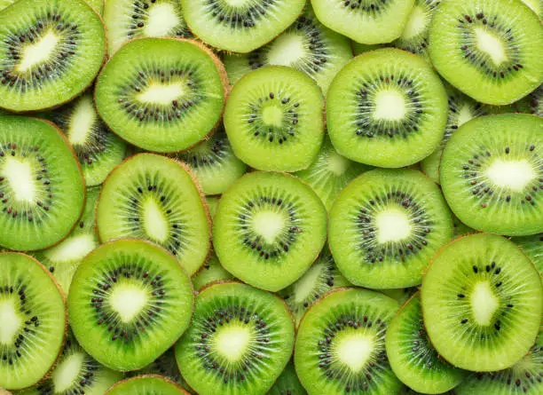 heap of sliced ripe kiwi as textured background