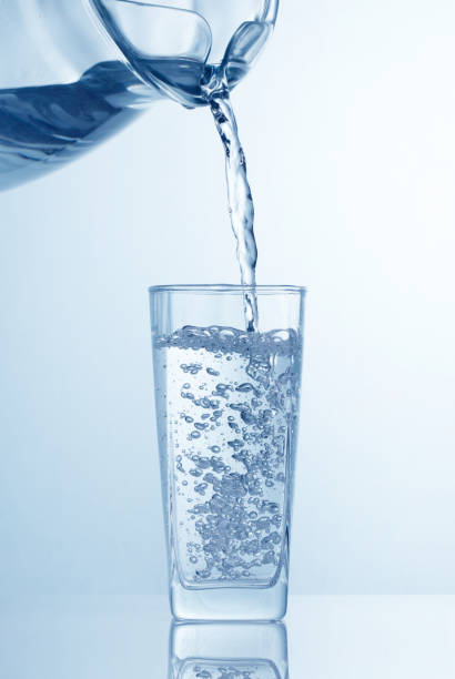 istock pouring water from pitcher into the glass 946905726