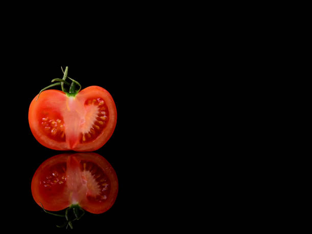 istock Tomato isolated on the black and glossy background with realistic reflection and water drops 946910044