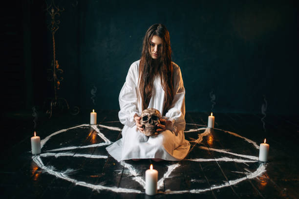 istock Woman holds human skull in hand, dark magic, witch 946913166