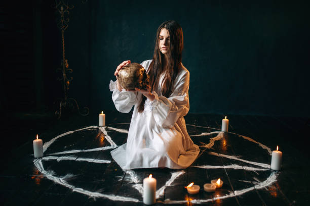 istock Woman holds human skull in hand, dark magic, witch 946913192