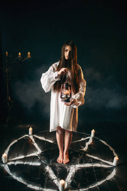 istock Woman holds kerosene lamp, pentagram circle, magic 946913524