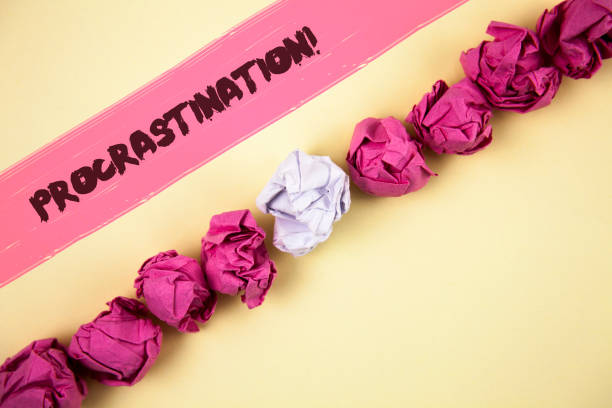 istock Handwriting text writing Procrastination Motivational Call. Concept meaning Delay or Postpone something boring written on Painted background Crumpled Paper Balls Line next to it. 946923626